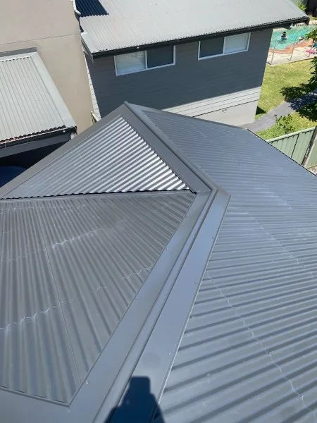 Grey metal re-roof with crisp hip and valley flashing