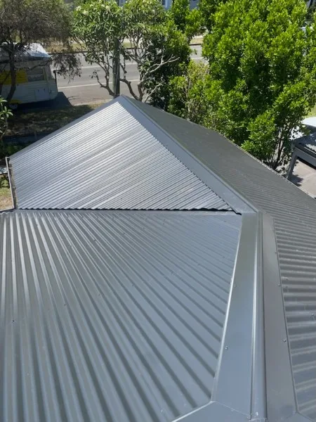 Newly installed Zincalume corrugated metal roof โ ridge detail